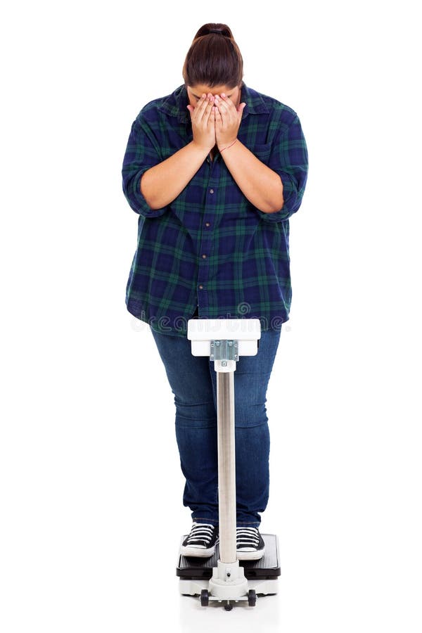 Unhappy overweight girl crying when weighting on scale. Unhappy overweight girl crying when weighting on scale