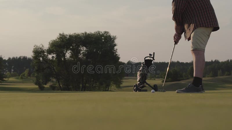 Niet erkend mensen speelgolf die golfbal op de golfcursus raken Het concept recreatie en sporten in openlucht