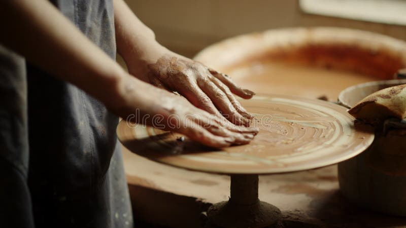 Niet-erkende dame wacht op klei in aardewerk. meisje dat rust heeft voor het sculperen