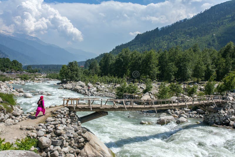Niet geïdentificeerde Indische vrouwengang op de houten brug dichtbij Vashisht-dorp in Kullu-vallei, Himachal Pradesh, India royalty-vrije stock afbeeldingen Niet geïdentificeerde Indische vrouwengang op de houten brug dichtbij Vashisht-dorp in Kullu-vallei, Himachal Pradesh, India royalty-vrije stock afbeeldingen