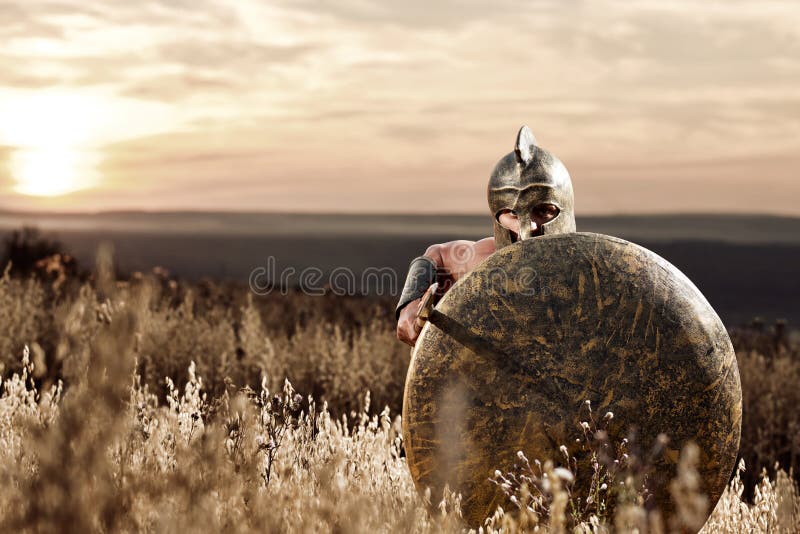 Nieustraszenie młody Spartański wojownik pozuje w polu