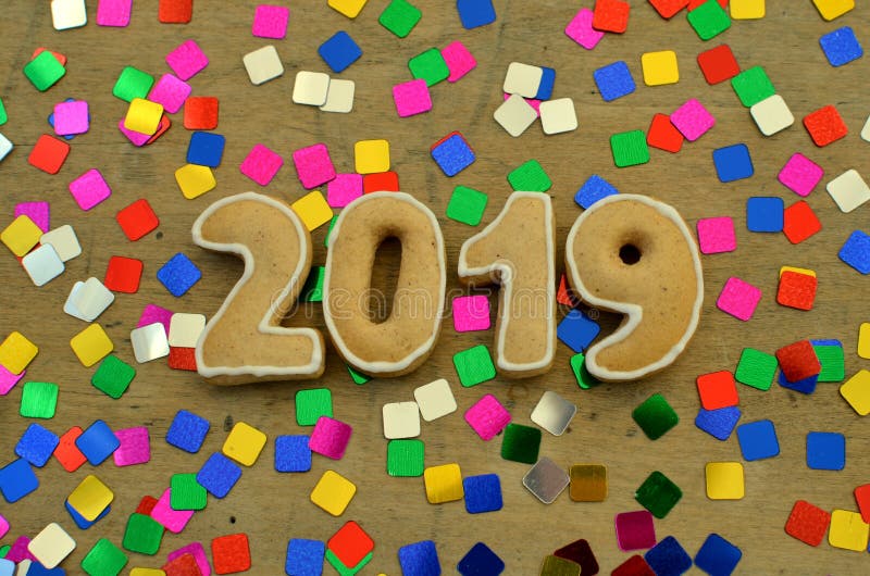 Nieuw jaar 2019 Peperkoekcijfers aangaande een houten raad Nieuwe jaargroeten Geschikt als achtergrond Kleurrijke lovertjes stock afbeelding Nieuw jaar 2019 Peperkoekcijfers aangaande een houten raad Nieuwe jaargroeten Geschikt als achtergrond Kleurrijke lovertjes stock afbeelding