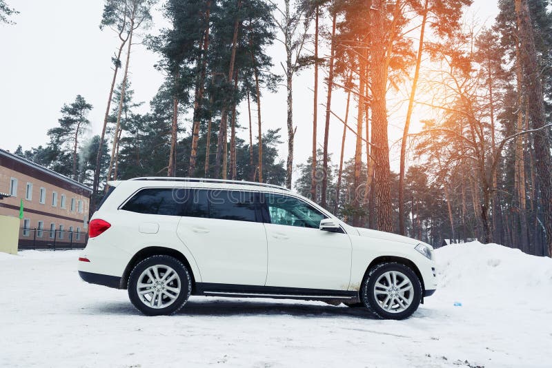 Nieuwe luxe autodieMercedes in bos bij de winteravond wordt geparkeerd stock fotografie Nieuwe luxe autodieMercedes in bos bij de winteravond wordt geparkeerd stock fotografie
