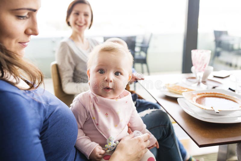 New mom friends going to restaurant with babies. Spending free time during maternity leave together in the city. New mom friends going to restaurant with babies. Spending free time during maternity leave together in the city.