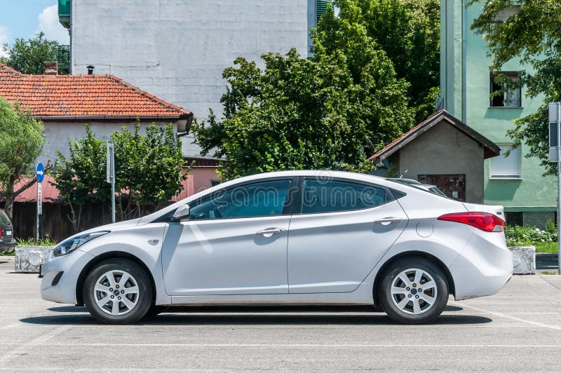 Nieuwe witte luxueuze Hyundai Elantra-limousinevijfdeursauto 2 Sportwagen 0 op het parkeerterrein in de stad wordt geparkeerd die royalty-vrije stock foto Nieuwe witte luxueuze Hyundai Elantra-limousinevijfdeursauto 2 Sportwagen 0 op het parkeerterrein in de stad wordt geparkeerd die royalty-vrije stock foto