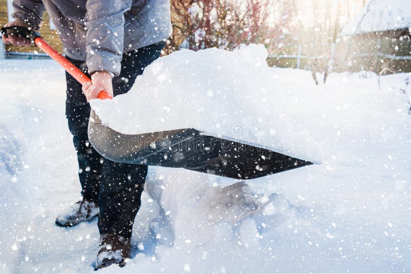 Nieve de vaciamiento del hombre por la pala después de nevadas outdoors imagen de archivo Nieve de vaciamiento del hombre por la pala después de nevadas outdoors imagen de archivo