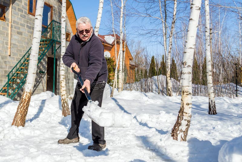 Nieve que lanza del hombre mayor con la pala de la yarda privada de la casa en invierno en día soleado brillante Persona mayor qu fotos de archivo Nieve que lanza del hombre mayor con la pala de la yarda privada de la casa en invierno en día soleado brillante Persona mayor qu fotos de archivo