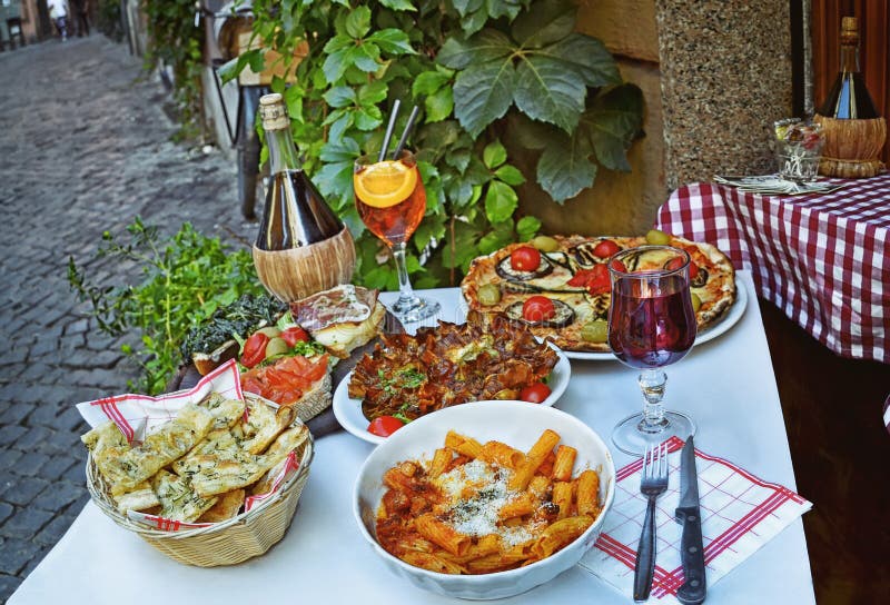 Niezidentyfikowani ludzie je tradycyjnego włoskiego jedzenie w plenerowej restauraci w Trastevere okręgu