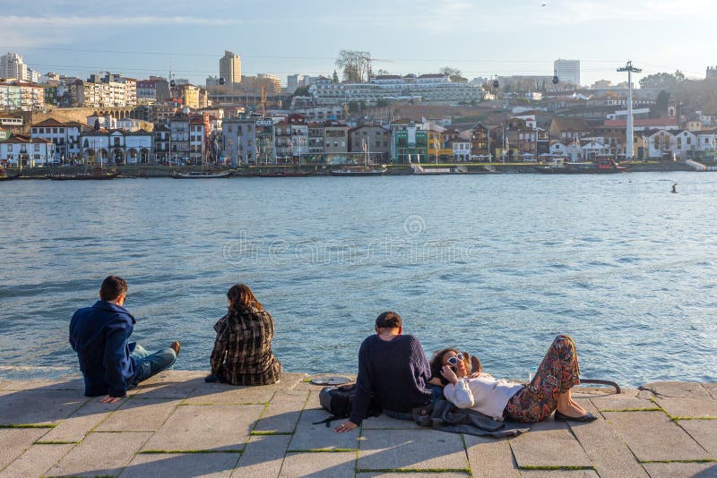Niezidentyfikowani ludzie odpoczywają na Douro brzeg rzekim przy słonecznym dniem w Porto, Portugalia fotografia stock Niezidentyfikowani ludzie odpoczywają na Douro brzeg rzekim przy słonecznym dniem w Porto, Portugalia fotografia stock