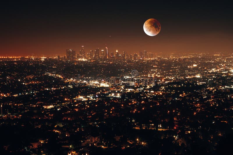 Night aerial view of city lights surrounded by buildings with a full moon in Los Angeles, USA royalty free stock photos