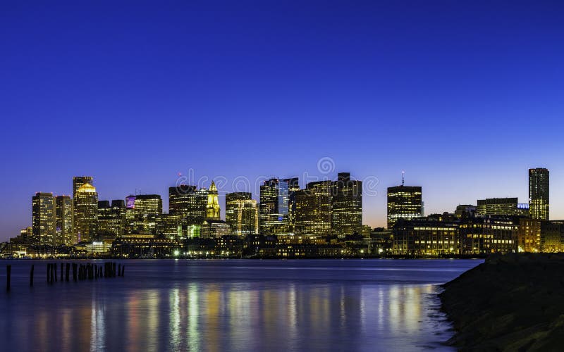 Night Cityscape of Boston Skyline over Boston Harbor on Blue Sky Background. Cityscape of East Boston at night with jetty, piers and light reflections. Photo was royalty free stock photography Night Cityscape of Boston Skyline over Boston Harbor on Blue Sky Background. Cityscape of East Boston at night with jetty, piers and light reflections. Photo was royalty free stock photography