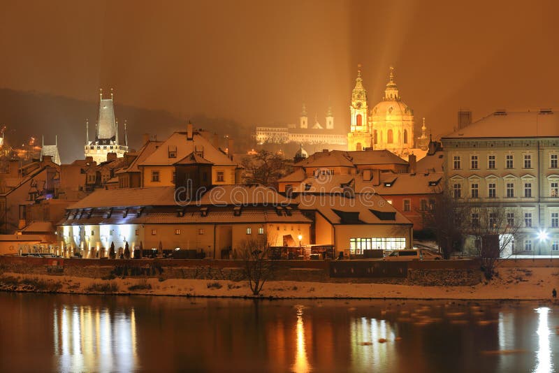 Night colorful romantic snowy Prague St. Nicholas' Cathedral, Czech republic