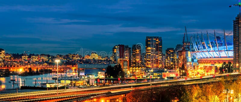 Night life of a huge seaside city with modern shining multicolored neon lights skyscrapers, top view