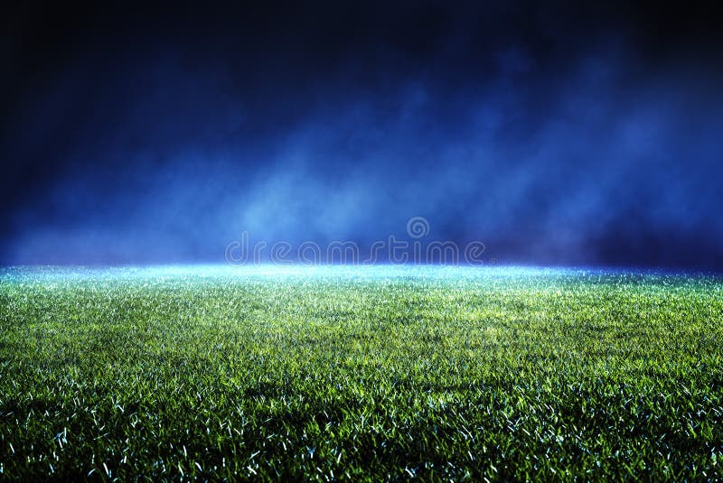 Night low view of maintained lawn at football stadium.