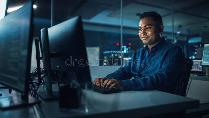 Night Office: Portrait of Handsome Indian Man in Working on Desktop Computer. Digital Entrepreneur royalty free stock image