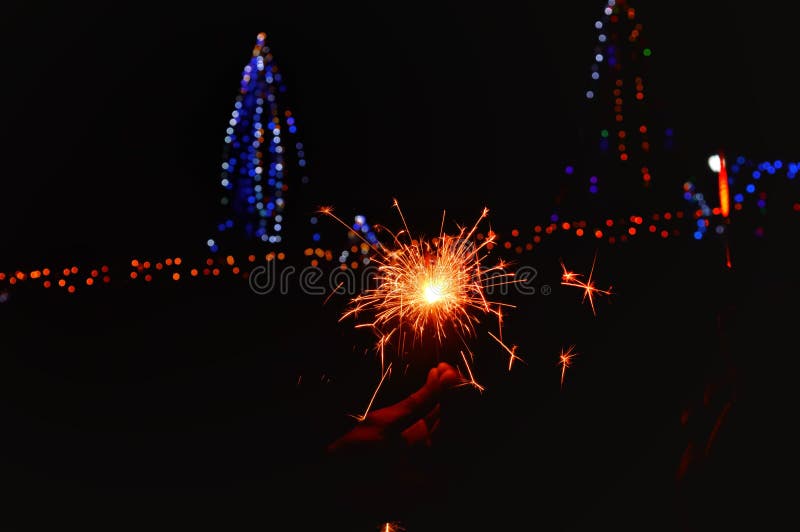 Night Party ,happy Diwali,Man`s Hand Holds Sparklers, Happy New Year,  Glowing Sparkler in Hand on Background of Oregon and Blue Stock Photo -  Image of background, diwali: 163147106