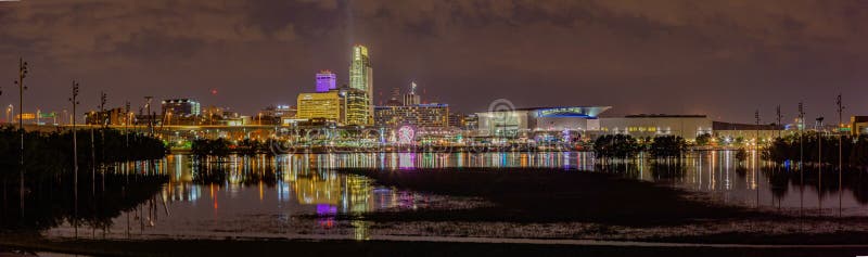 Night scene panoramic view of Omaha riverfront with flooded Tom Hanafan river`s edge park Council Bluffs Iowa