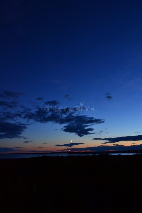 Night Sky above Manistique Michigan Lighthouse in Vertical View with Moon