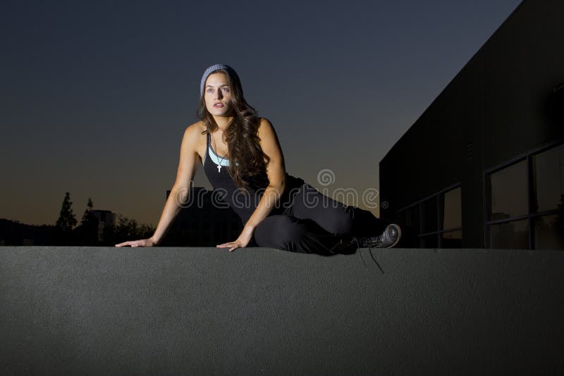 Free runner scaling or climbing a wall at night to do parkour. Female climbing high risk building stock images, royalty-free photos and pictures
