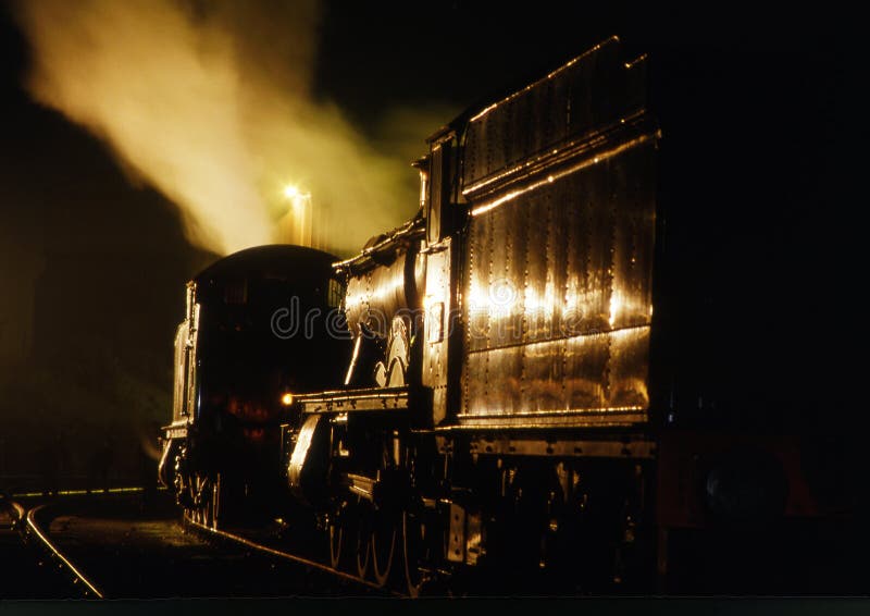 Vintage steam train with golden lighting at night. Night train stock images, royalty-free photos and pictures