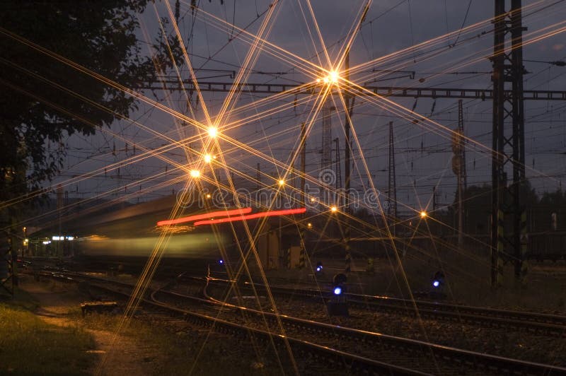 Noche el tren llega sobre el estación.