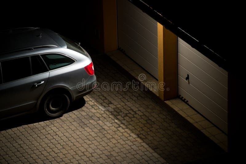 Night view of grey car parked in front of the garage