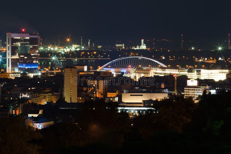 Night view on the city. Red lights, buildings, bridge and factory