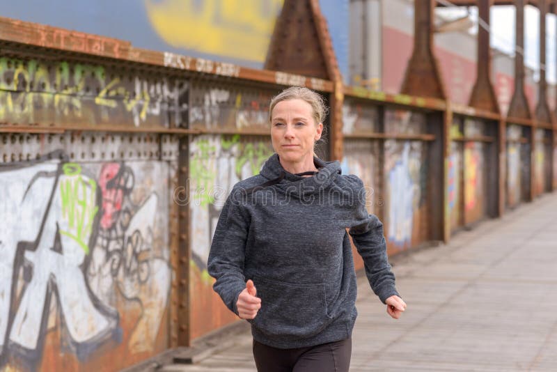 Nikła sportowa kobieta jogging na moscie zdjęcie stock