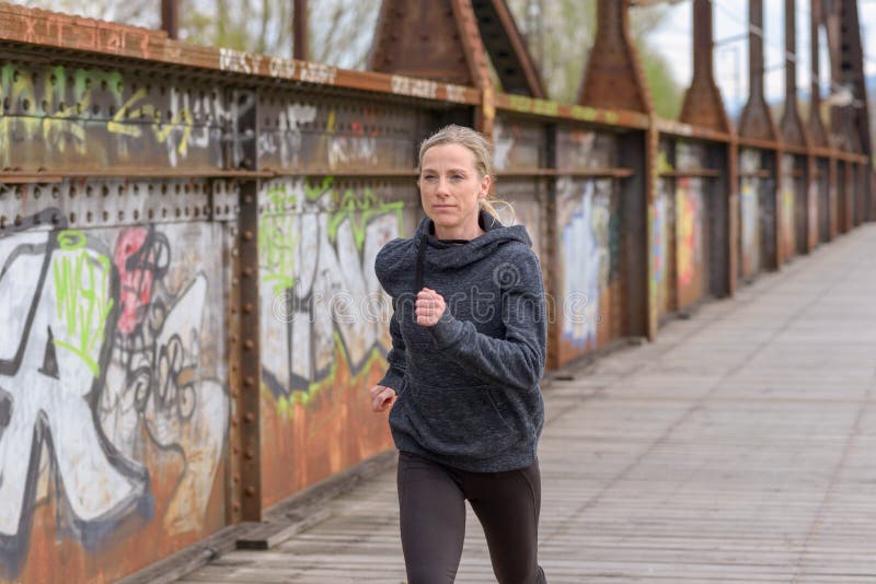 Nikła sportowa kobieta jogging na moscie zdjęcia royalty free