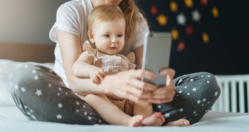 Nine-month-old Baby Girl Sits with Her Mother and Looks on Smartphone  Cartoons. Child is Talking To Her Grandmother Via Video Link Stock Photo -  Image of babe, education: 158641092