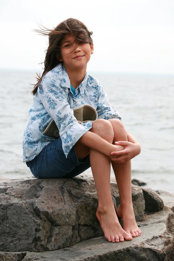 Nine year old girl sitting by lake