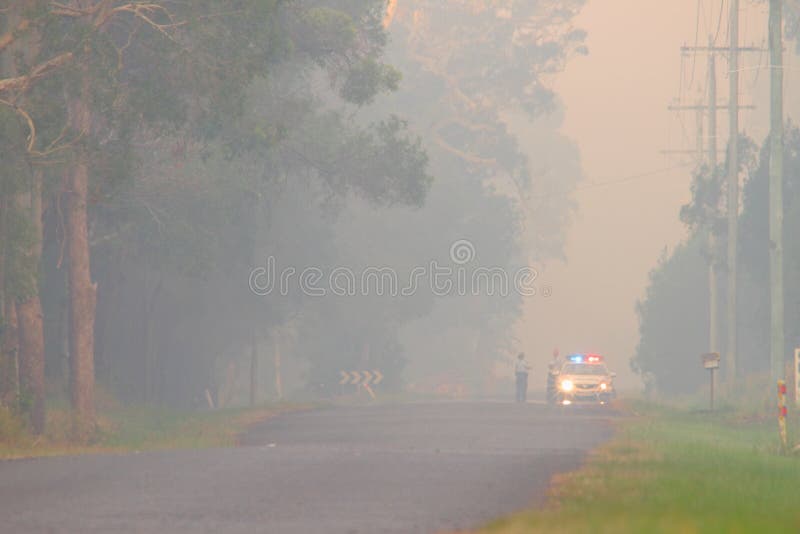 NINGI AUSTRALIA, LISTOPAD, - 9: Milicyjny mienie kordon przed krzaka ogienia przodem gdy ono zbliża się domy Listopad 9, 2013 w Ni