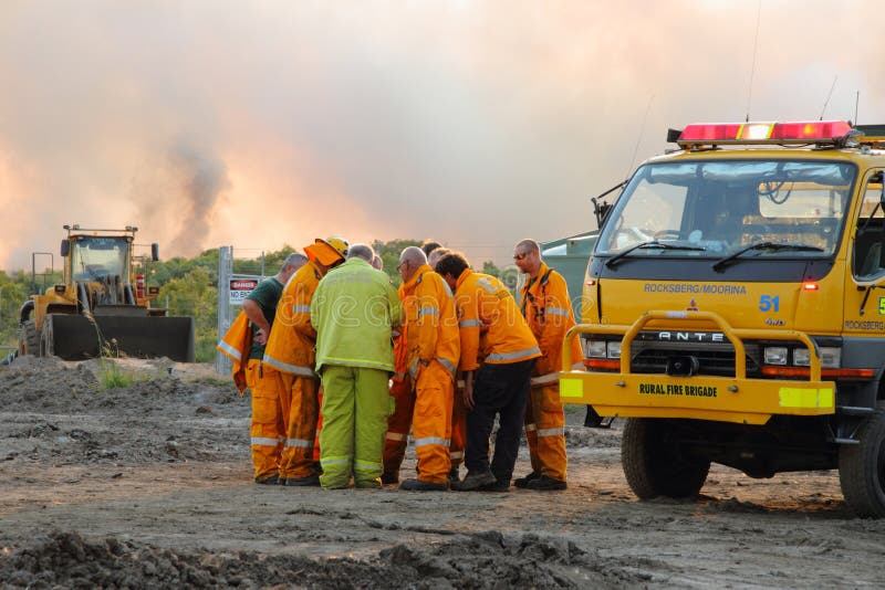 NINGI AUSTRALIA, LISTOPAD, - 9: Strażak załoga dicussing podejścia ogienia przód krzaka ogień Listopad 9, 2013 w Ningi, Austra