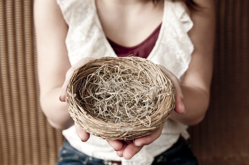 Young girl holding an empty nest. Young girl holding an empty nest