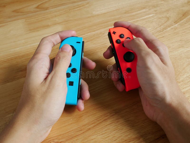 Nintendo-Schakelaarcontrolemechanismen in handen worden gehouden die royalty-vrije stock afbeeldingen Nintendo-Schakelaarcontrolemechanismen in handen worden gehouden die royalty-vrije stock afbeeldingen