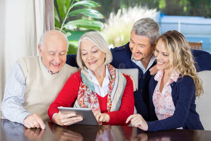 Nipoti che esaminano usando dei nonni fotografie stock libere da diritti Nipoti che esaminano usando dei nonni fotografie stock libere da diritti