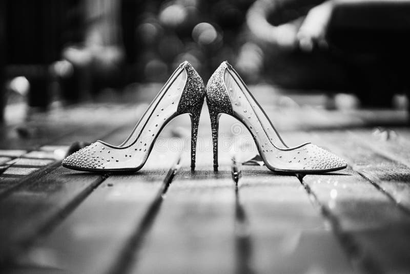 Niski kąt szpilki błyskotliwości kobiet butów miejsce na drewnianej podłoga w czarny i biały