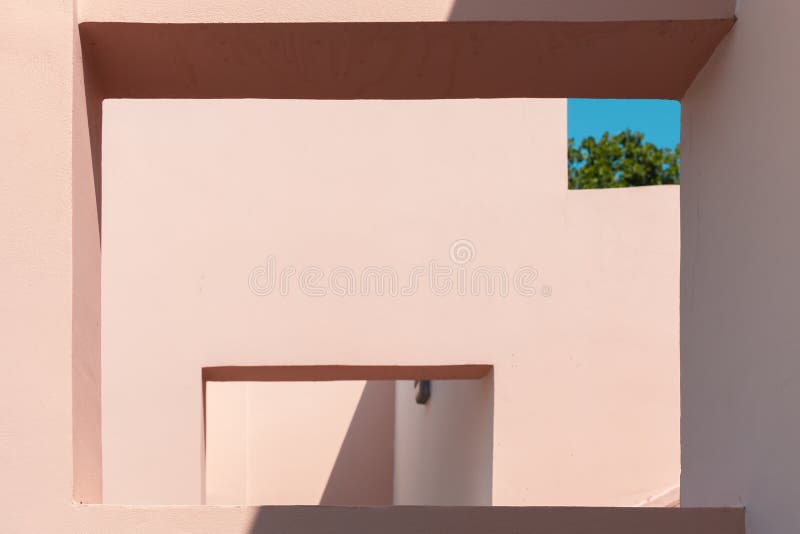 Abstract contemporary architecture photo, niches in pink painted concrete walls under blue sky. Abstract contemporary architecture photo, niches in pink painted concrete walls under blue sky