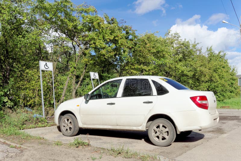 Nizhny Novgorod, Russia. - September 06.2016. A white passenger car with a disabled driver sign on the rear window is parked in a