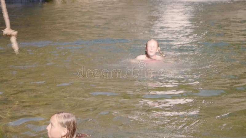 Niña adolescente nadando en el lago en el paisaje de las cascadas de montaña. Jovencita disfrutando de agua dulce en un lago frà metrajes