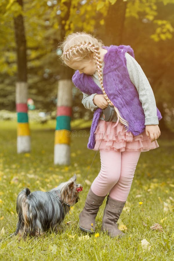 Niña adorable que juega con su perrito fotografía de archivo