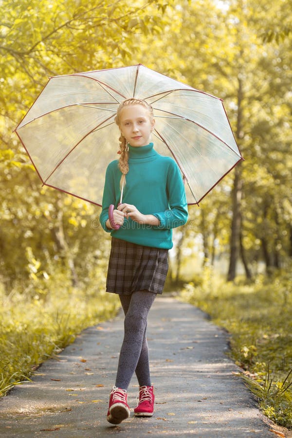 Adorable niña pequeña posando con un paraguas en el parque fotografía de archivo libre de regalías