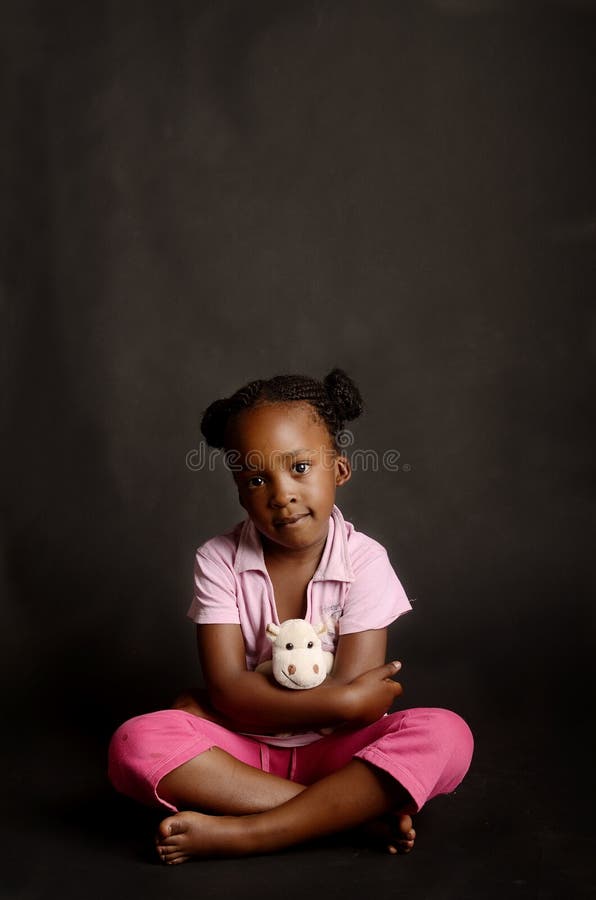 Niña africana triste que se sienta solamente imagen de archivo libre de regalías Niña africana triste que se sienta solamente imagen de archivo libre de regalías