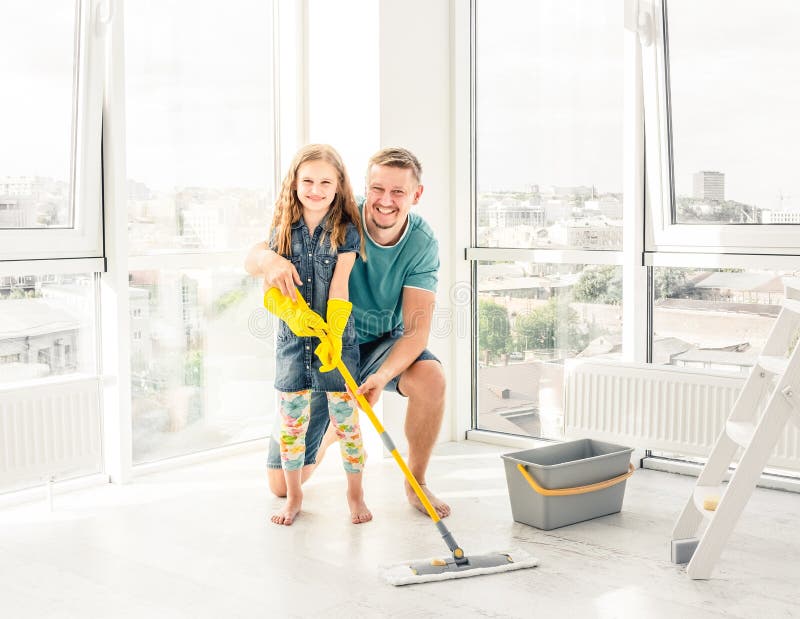 Niña con el padre que limpia el piso foto de archivo libre de regalías Niña con el padre que limpia el piso foto de archivo libre de regalías