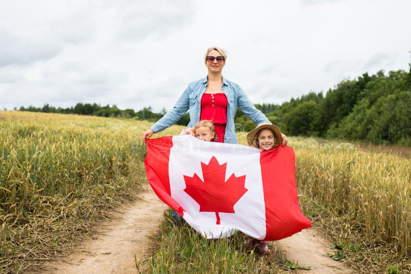 Niña con niños en el campo de juego con bandera canadiense fotos de archivo libres de regalías