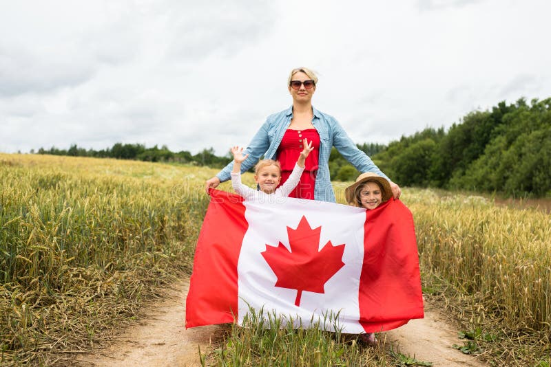 Niña con niños en el campo de juego con bandera canadiense fotografía de archivo libre de regalías