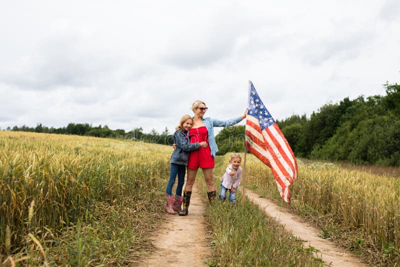 Niña con niños en el campo de juego con bandera de los estados unidos foto de archivo