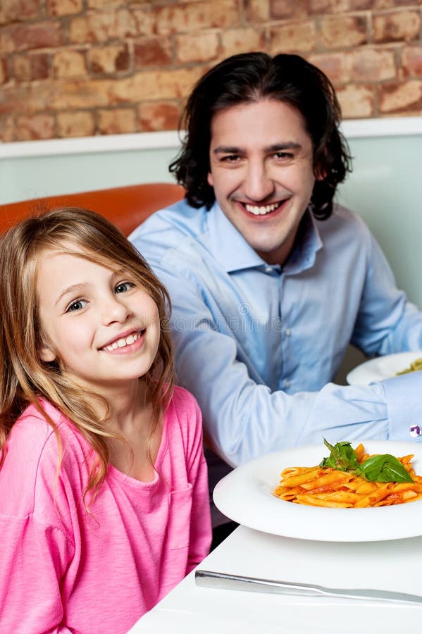 Niña con su padre en restaurante foto de archivo libre de regalías Niña con su padre en restaurante foto de archivo libre de regalías