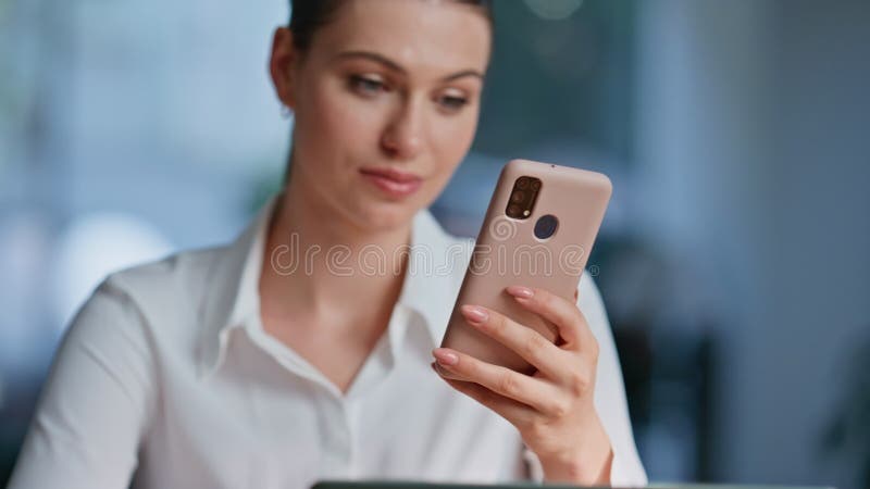 Niña consultando la aplicación de banca de celulares en el armario de la oficina. Mujer sonriente fotografía de archivo