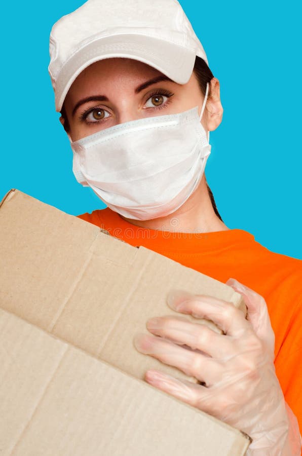 Niña de parto lleva mascarilla médica y guantes y sostiene dos cajas de retrato de cierre. concepto de servicios seguros durante c fotografía de archivo
